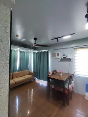 a living room with a couch and a table at Two Bedroom - Presidio Lakefront in Manila