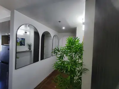 a hallway with mirrors and a potted plant at Two Bedroom - Presidio Lakefront in Manila