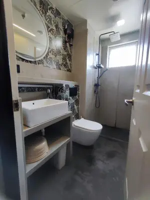 a bathroom with a sink and a toilet and a mirror at Two Bedroom - Presidio Lakefront in Manila