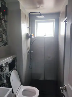 a small bathroom with a toilet and a window at Two Bedroom - Presidio Lakefront in Manila
