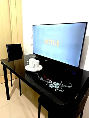 a black desk with a tv and two cups on it at Sea Residences - Jan 0976-206-7884 in Manila