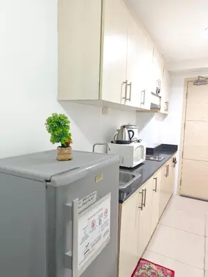 a kitchen with white cabinets and a refrigerator at Sea Residences - Jan 0976-206-7884 in Manila