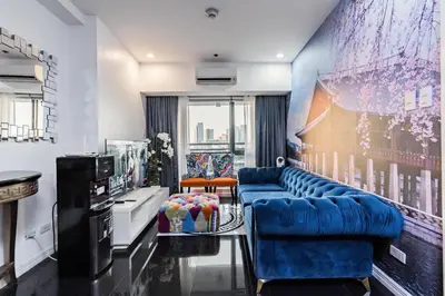 a living room with a blue couch and chairs at Makati City Centre Condo in Manila