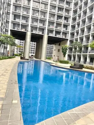 a large blue swimming pool in front of a building at Shore2 tower2 in Manila