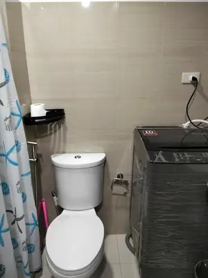 a bathroom with a white toilet in a room at Shore2 tower2 in Manila