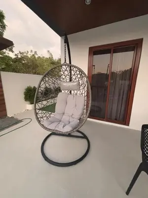 a hanging chair with pillows on a patio at Villa Serene Resort in General Trias