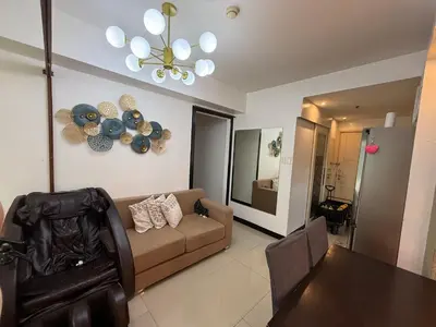 a living room with a couch and a chandelier at Staycation By Abby Tower E in Manila