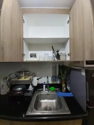 a kitchen with a sink and a microwave at Chic Urban Retreat near mall of asia in Manila