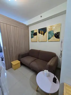 a living room with a couch and a table at Chic Urban Retreat near mall of asia in Manila