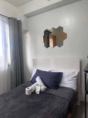 a bedroom with a bed with two towels on it at Chic Urban Retreat near mall of asia in Manila