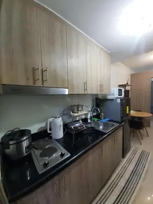 a kitchen with a stove and a counter top at Chic Urban Retreat near mall of asia in Manila
