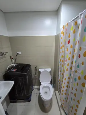 a small bathroom with a toilet and a sink at Shore 2 Tower 3 Chic and Cozy by Richnells in Manila