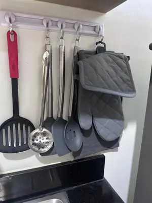 a bunch of kitchen utensils hanging from a wall at Shore 2 Tower 3 Chic and Cozy by Richnells in Manila