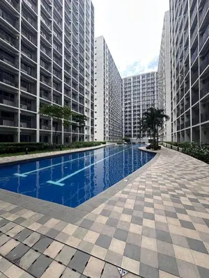 a swimming pool in the middle of two tall buildings at Shore 2 Tower 3 Chic and Cozy by Richnells in Manila