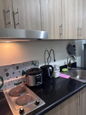 a kitchen counter with a stove and a sink at Shore 2 Tower 3 Chic and Cozy by Richnells in Manila