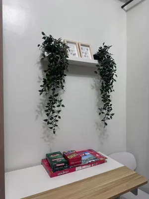 a shelf with plants and books on a table at Shore 2 Tower 3 Chic and Cozy by Richnells in Manila