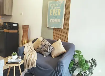 a blue couch with pillows on it in a living room at Ortigas Business District Residences in Manila