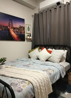 a bedroom with a bed with a picture on the wall at Ortigas Business District Residences in Manila