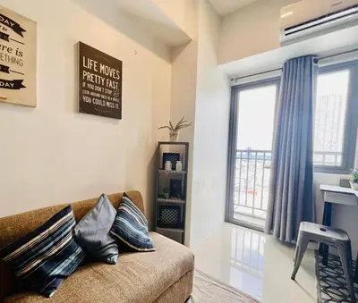 a living room with a couch and a window at Ortigas Business District Residences in Manila
