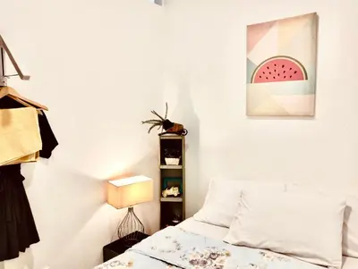 a bedroom with a bed and a painting of a watermelon at Ortigas Business District Residences in Manila
