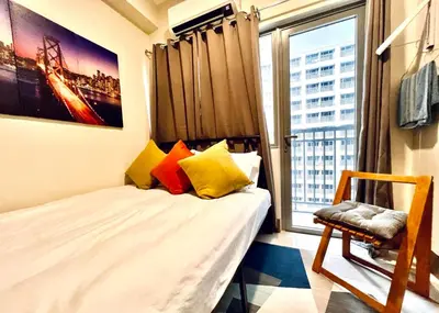 a small bedroom with a bed and a window at Ortigas Business District Residences in Manila