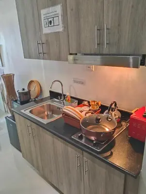 a kitchen with a sink and a stove top oven at Ortigas Business District Prime Accommodations in Manila