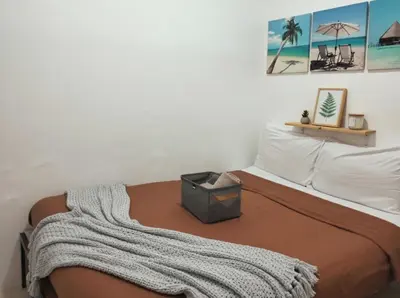 a bedroom with a bed with a blanket on it at Ortigas Business District Prime Accommodations in Manila