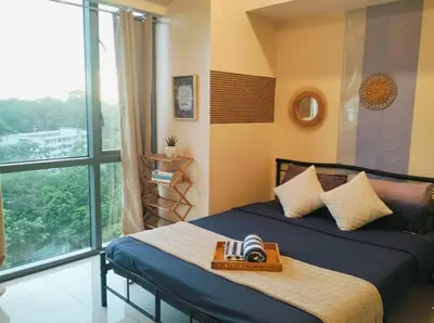 a bedroom with a bed and a large window at BGC Mckinley Center Prime Accommodations in Manila