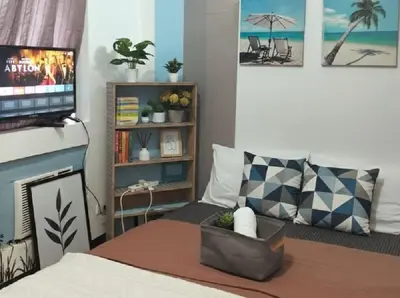 a living room with a bed with a tv and a couch at BGC Mckinley Center Prime Accommodations in Manila