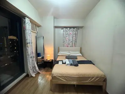 a bedroom with two beds and a window at FLAIR Condotel 1 BR Near MRT EDSA Shangrila Megamall Lightmall in Manila