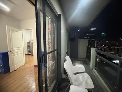 a room with two white chairs and a view of a city at FLAIR Condotel 1 BR Near MRT EDSA Shangrila Megamall Lightmall in Manila