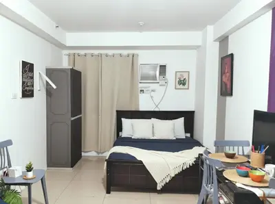 a bedroom with a bed and a table and chairs at Mall of Asia - Aseana Residences in Manila