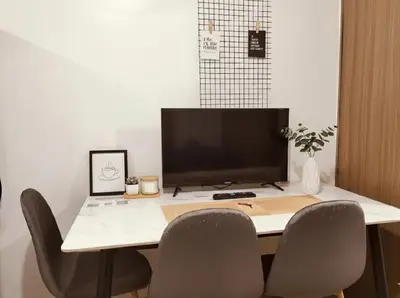 a desk with two chairs and a computer monitor on it at Mall Of Asia - Aseana Prime Accommodations in Manila