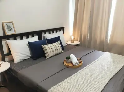 a bedroom with a large bed with blue and white pillows at Makati Business District Residences in Manila