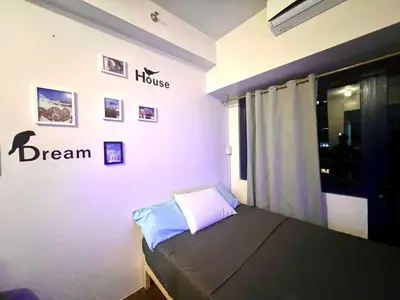 a bedroom with a bed and a dream sign on the wall at Makati Business District Residences in Manila