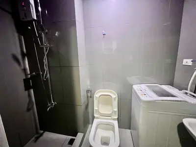 a small bathroom with a toilet and a sink at Makati Business District Residences in Manila
