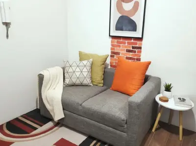a gray couch with colorful pillows in a living room at Makati Business District Residences in Manila