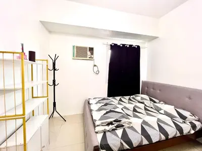 a bedroom with a bed and a black window at Makati Business District Prime Accommodations in Manila