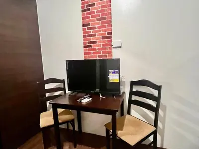 a desk with a television on it with two chairs at Makati Business District Prime Accommodations in Manila