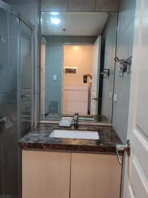 a bathroom with a sink and a large mirror at Pool View BP1043 in Manila
