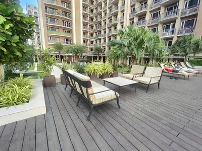 a deck with chairs and tables in front of a building at Pool View BP1043 in Manila