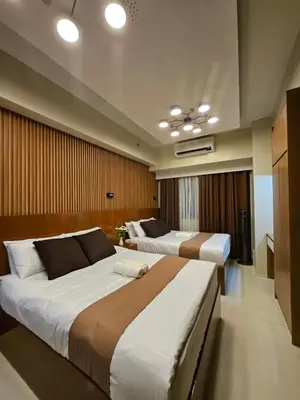 a bedroom with two beds and a television at Modern Condotel 2Beds near MOA in Manila