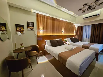 a hotel room with two beds and a table at Modern Condotel 2Beds near MOA in Manila