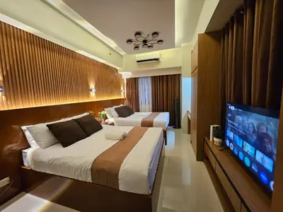 a bedroom with two beds and a flat screen tv at Modern Condotel 2Beds near MOA in Manila