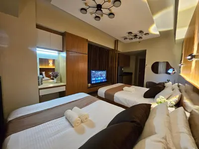 a hotel room with two beds and a couch at Modern Condotel 2Beds near MOA in Manila
