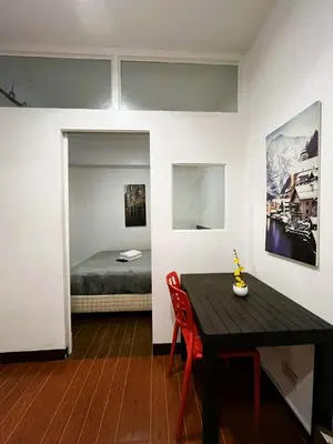 a room with a table and a bed and a bedroom at BGC Suites EDSA Makati in Manila