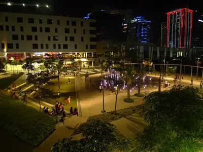 a city square at night with people walking around at BGC Suites EDSA Makati in Manila