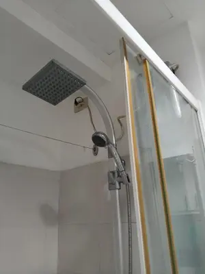 a shower with a shower head in a bathroom at Mall Of Asia Sea Condotel in Manila