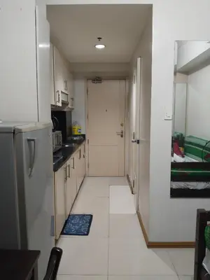 a kitchen with a hallway leading to a door at Mall Of Asia Sea Condotel in Manila
