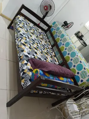 a bed with colorful pillows on it in a room at Mall Of Asia Sea Condotel in Manila